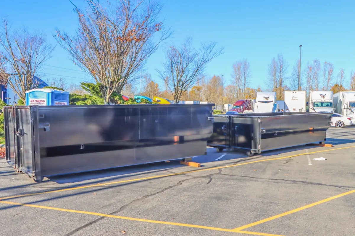 Professional dumpster rental service with roll-off container on residential driveway in Indio